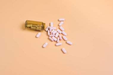 Turuncu bir arka plan üzerinde kahverengi cam şişe pembe hap