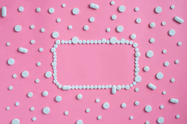Witte pillen op roze achtergrond. Ruimte voor tekst kopiëren — Stockfoto