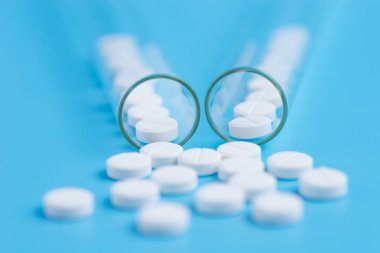 Tıp beyaz hap mavi arka plan üzerinde test tüpü içinde. Kopya s