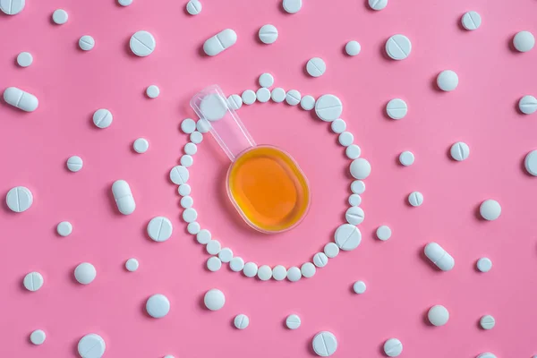En un círculo de tabletas o pastillas blancas una cuchara con jarabe para la tos — Foto de Stock