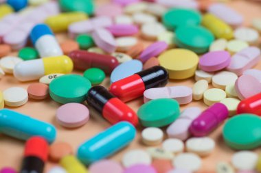 Turuncu arka planda renkli tabletler ve haplar