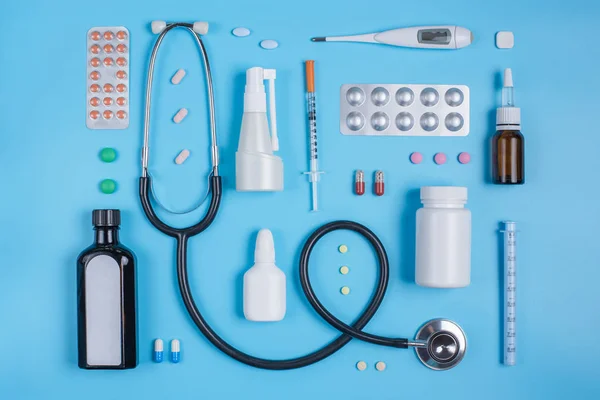 Stetoskop a prášky v puchýře na modrém pozadí. — Stock fotografie