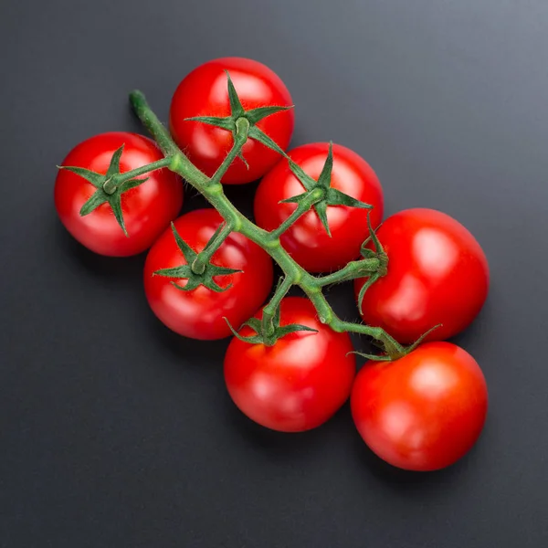 Nádherná červená rajčata na černém pozadí, zblízka. — Stock fotografie