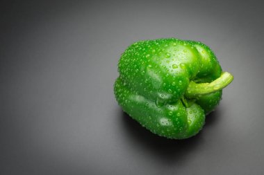 Siyah bir arka plan üzerinde su damlaları ile Yeşil biber.