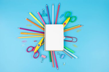 Renkli okul malzemeleri ve mavi bir not defteri. Okul