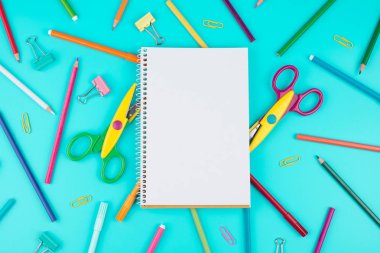 Renkli okul malzemeleri ve mavi bir not defteri. Okul