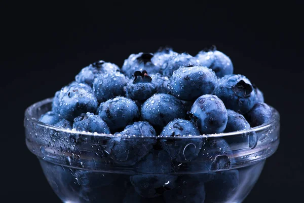 Fresh Blueberry. Blueberries in a glass plate on a black backgro — Stock Photo, Image