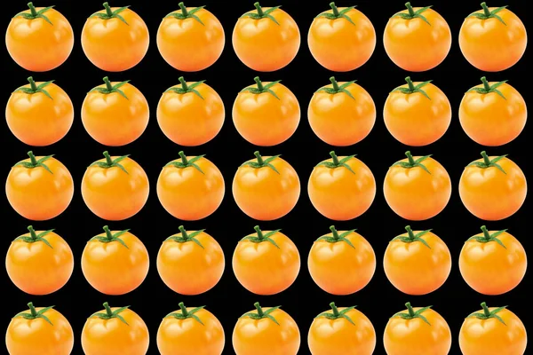 Vegetable pattern of yellow tomatoes on black background. — Stock Photo, Image