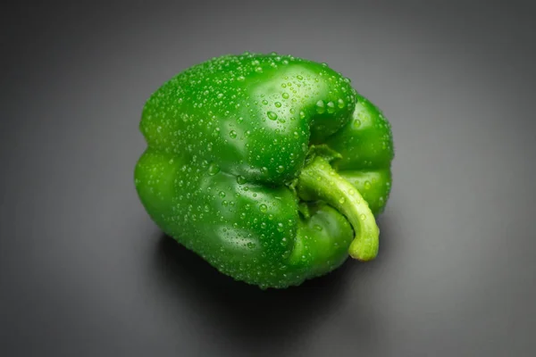 Fresh green pepper with water drops on a black background — Stock Photo, Image