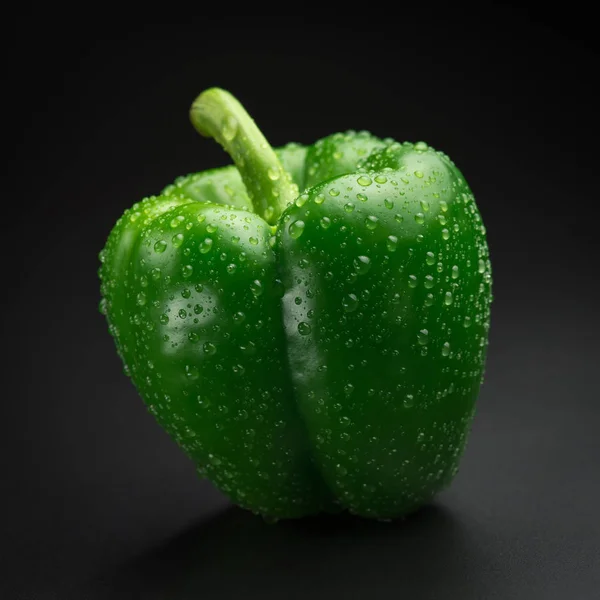 Green pepper with water drops on a black background. Fresh brigh — Stock Photo, Image