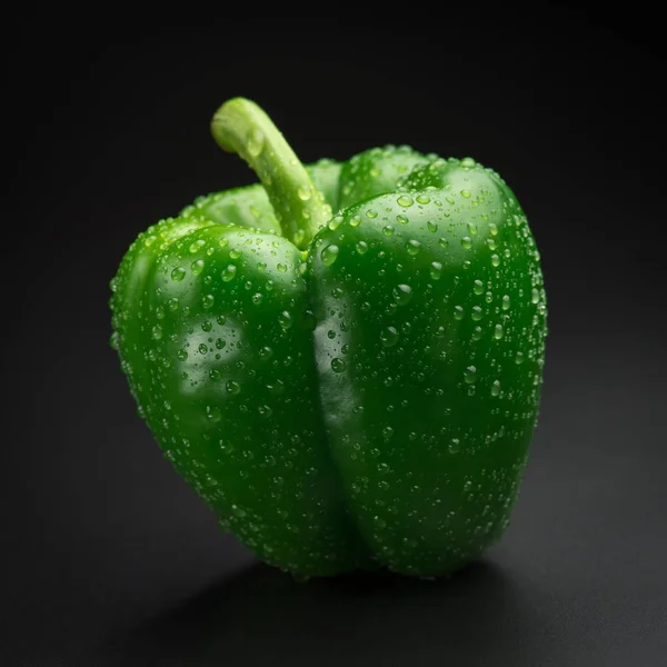 Pimenta verde com gotas de água em um fundo preto. Brilho fresco — Fotografia de Stock