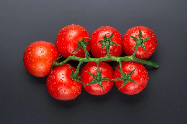 검은 배경에 방울이있는 아름다운 빨간 토마토. 로열티 프리 스톡 사진