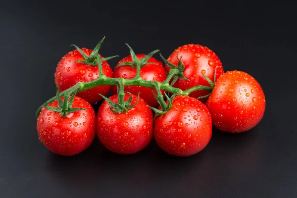 Свежие красные помидоры с капельками на черном фоне . — стоковое фото