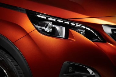 Modern bir arabanın farlarını yaktı.