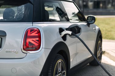 Katowice / Poland - 05.09.2020 : First fully electric Mini connected to a charging station. The Mini has a range of up to 230 km, 184 hp engine and accelerates from 0 to 100 km/h in 7.3 seconds. clipart