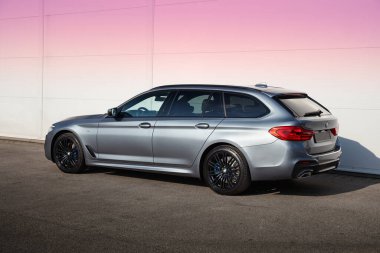 Varşova / Polonya - 05.17.2017: Parlak mavi BMW 5 Serisi Turnesi, beyaz bir duvarın altında duruyor. Arabanın arka tarafına bak..