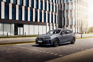 Katowice / Polonya, 18.07.2020: Gri BMW 1 M Sport versiyonu, modern bir ofis binasının önünde park edilmiş. Başka araba ve insan yok..