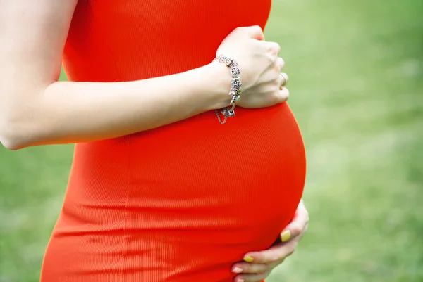 makro bebek şiş, kırmızı elbiseli bir hamile kadın