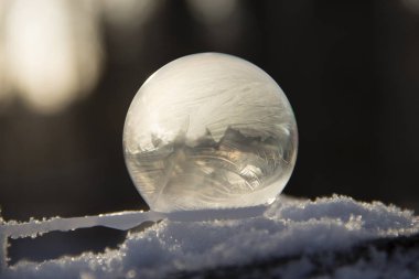 Arka planda bir bokeh ile karda donmuş kabarcık. Donmuş sabun köpüğü güzel soğuk desenler.