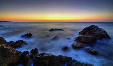 Kayalık kıyıüzerinde güzel gündoğumu