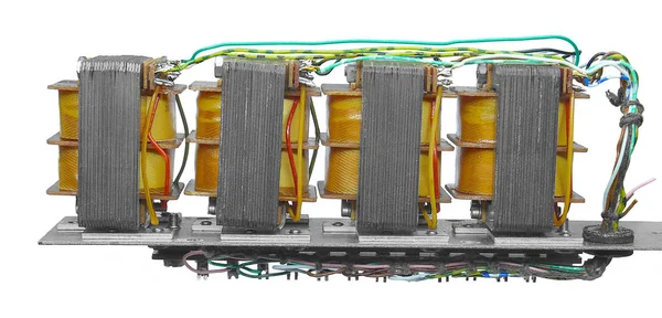 Tellere bağlanan ve metal üzerine sabitlenmiş dört transformatör 