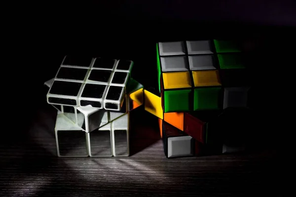 多色立方体和单声道立方体并排站在光滑的表面上 它们的体积和颜色不同 — 图库照片