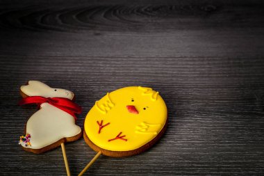 Bir tavşan şeklinde bir sopa Paskalya Gingerbread ve bir tavuk şeklinde bir ahşap masada yalan