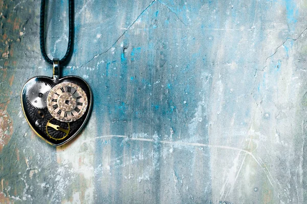 bir kalp ve bir saat şeklinde bir vintage kolye bir çatı tarzında duvara asılı; aşk için her zaman zaman olduğunu göstermek için kavram