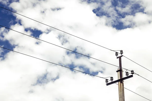 yüksek gerilim telleri ve aralarında bir elektrik direği kalın bulutlar ile pitoresk bir gökyüzü altında yer almaktadır