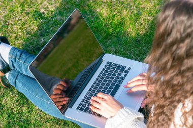 yeşil çim laptop kullanarak kadın kırpılmış shot