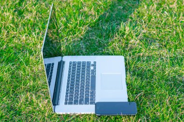 yeşil çim üzerinde Smartphone ile Laptop yakın çekim shot