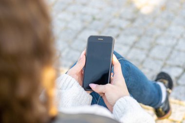 kadının sokakta smartphone kullanarak kırpılmış atış
