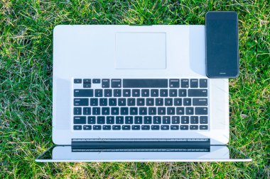 yeşil çim üzerinde Smartphone ile Laptop yakın çekim shot