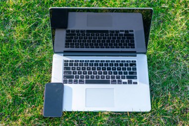 yeşil çim üzerinde Smartphone ile Laptop yakın çekim shot