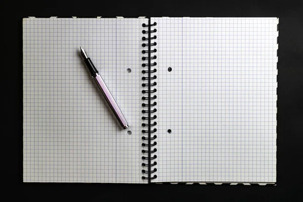 Caderno, caneta, fundo preto. Espaço de cópia da vista superior — Fotografia de Stock