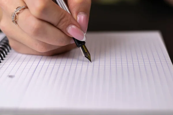Close shot van een menselijke hand iets schrijven op het papier op de — Stockfoto