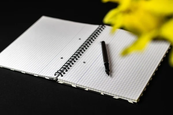 Caderno e caneta sobre um fundo preto — Fotografia de Stock