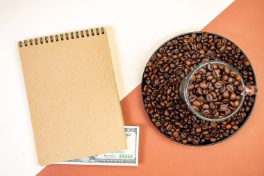 fincan ve tabak yüz dolar fatura ve dizüstü ile kavrulmuş kahve çekirdekleri dolu üst görünümü