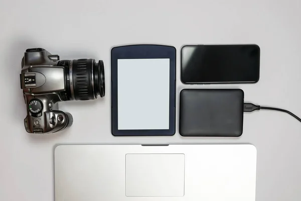 Travel gadgets flat lay on white background