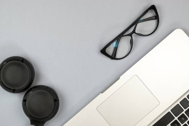 Dizüstü bilgisayar, gözlük ve diğer öğelerle ofis masasının görünümü