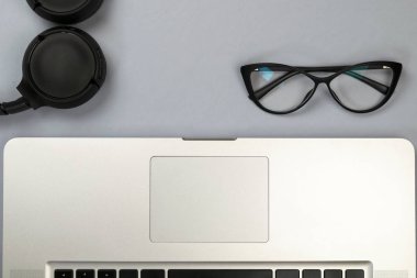 Dizüstü bilgisayar, gözlük ve diğer öğelerle ofis masasının görünümü