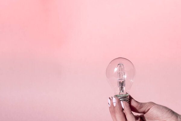 Close up view of white light bulb isolated on pink.