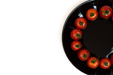 Beyaz arka planda izole edilmiş siyah bir tabakta domates. Beyaz bir arka plan üzerinde kırmızı domates Kompozisyon. Metin için yer