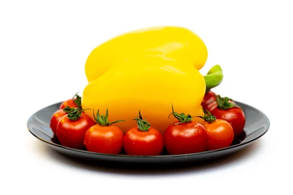 白い背景に隔離された黒いプレートにトマトと黄色の甘いコショウ 白い背景に黄色いピーマンと赤いトマトの構成 — ストック写真
