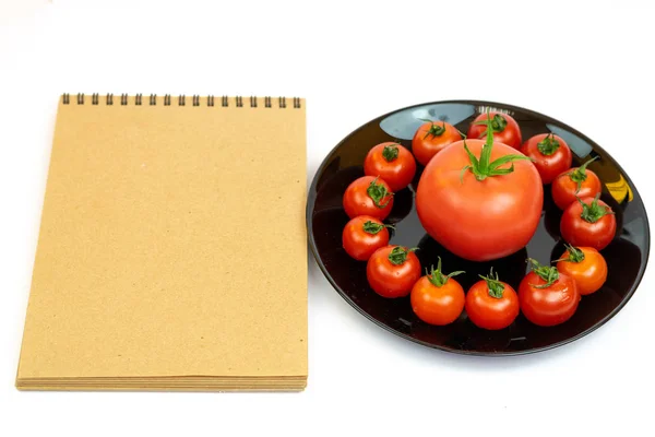 Tomates Uma Placa Preta Isolada Fundo Branco Perto Bloco Notas — Fotografia de Stock