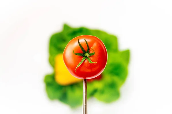 番茄在勺子上 背景是模糊的五颜六色的蔬菜 五颜六色的构图 — 图库照片