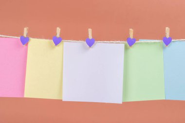 Renkli kağıt kartları kahverengi arka plan üzerinde izole ip asılı. Metniniz için yer.