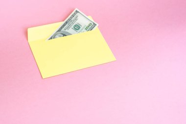 Sarı zarf içinde para yakın pastel pembe arka plan üzerinde yatıyor. Markalama alay; pembe arka planda ön görünüm. 
