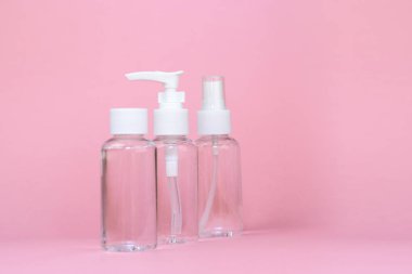 Güzellik kozmetik cam şişesi; markalama alay; pastel pembe arka plan ön görünüm. Uçucu yağ için paket.