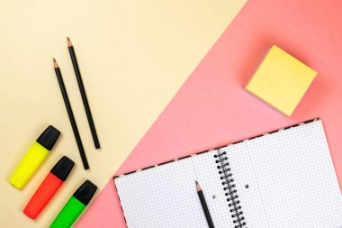 Pastel pembe ve bej arka planda okul malzemeleri, defter ve renkli işaretler. Marka kırtasiye maket sahnesi, tasarımınızı yerleştirmek için boş nesneler.
